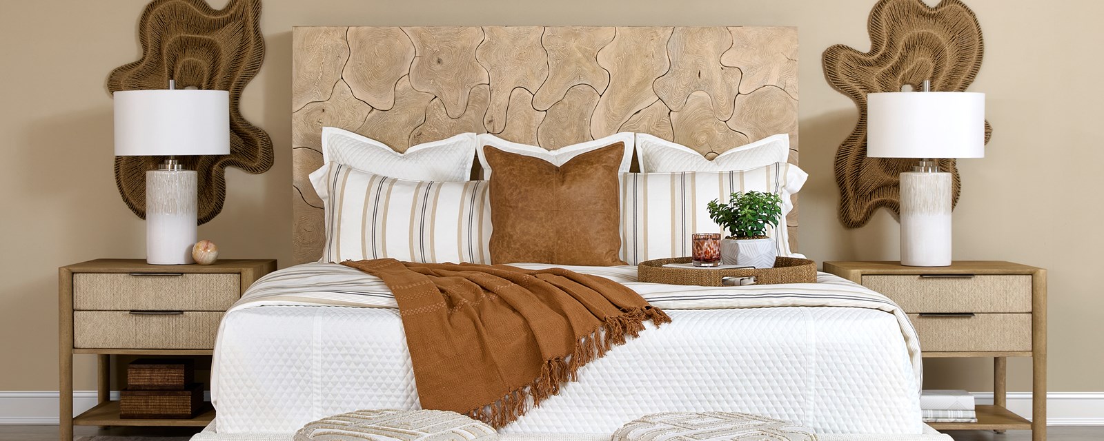 Image of a bed with a unique wooden headboard, terracotta accents and a beige wall.