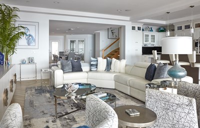 Image of a white leather setional in a living room with blue, white, grey coastal decor.