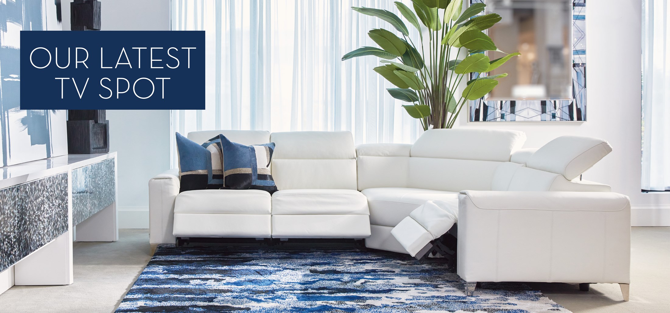 Image of the Eclettico Sectional with blue decor. Text: Our Latest TV Spot. Links to Latest TV Spot on Youtube.