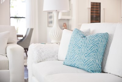 Blue accent pillow on a white sofa.