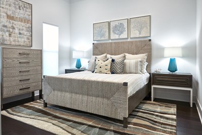 Neutral coastal bedroom with woven bed, brown and light blue color palette.