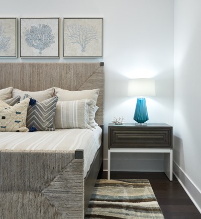 Neutral coastal bedroom with woven bed, brown and light blue color palette.