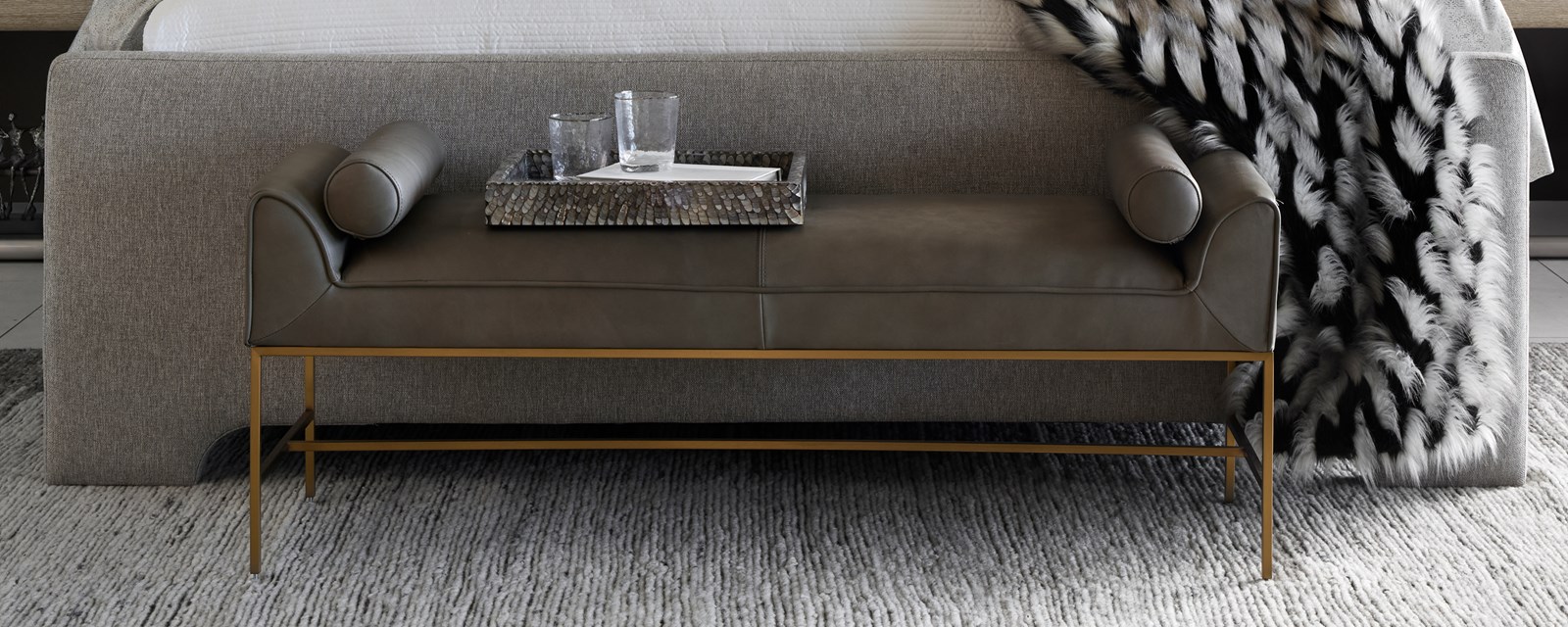 Image of a dark grey bench at the foot of a bed.