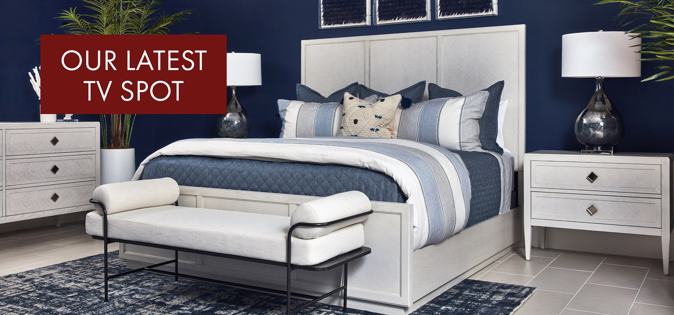 Image of the Weston Bedroom with blue bedding and accessories. Red Box with text: Our Latest TV Spot. Links to TV Spot on Youtube.