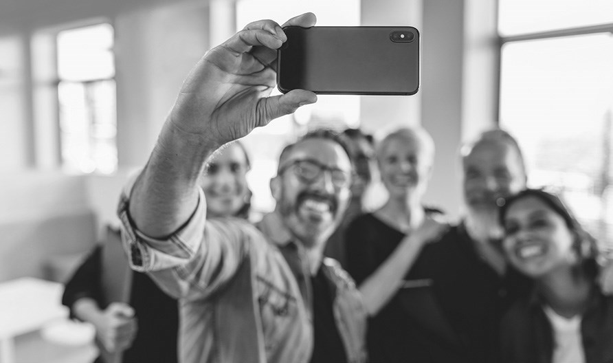 A team of individuals taking a group selfie. Links to Meet the Designers,